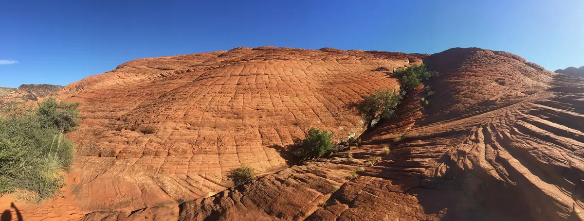 Panorama of swirling red cross-bedded Navajo Sandstone slickrock in Snow Canyon State Park.